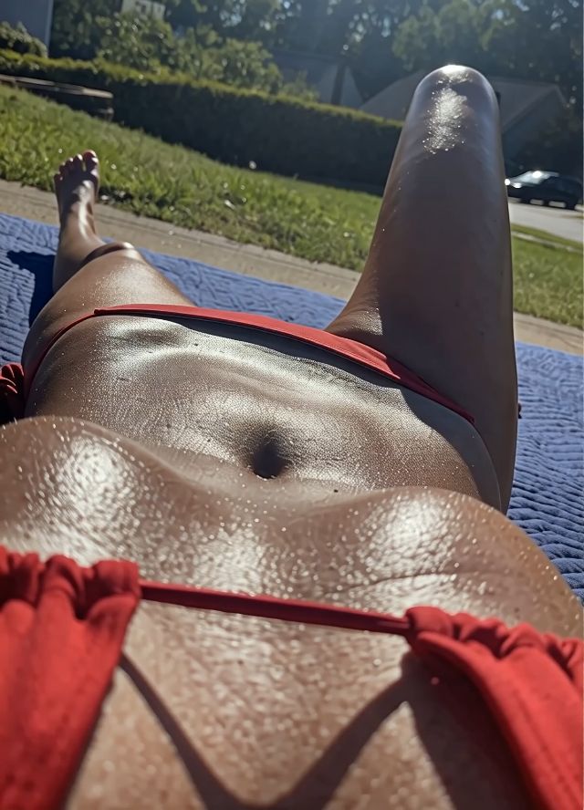 The woman laying outdoors starts putting her hand in her underwear and touching her vulva while keeping the underwear o…